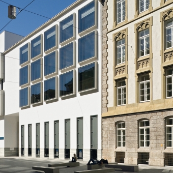 BTV Zentrale in Innsbruck Außenansicht: Weißes, modernes Gebäude mit vielen Fenstern zwischen zwei Altbau-Gebäuden