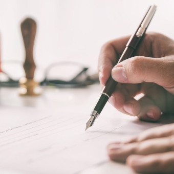 Notar unterschreibt einen Vertrag