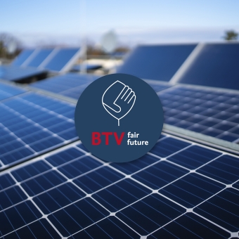 Blaues Logo über einem Bild mit Solaranlagen.