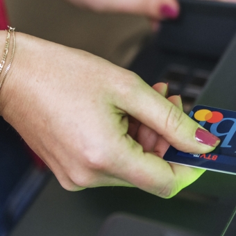 Eine Frau steckt eine Debitkarte in einen Geldautomaten.