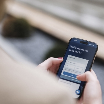 Eine Frau schaut in ihr Handy und sieht meineBTV