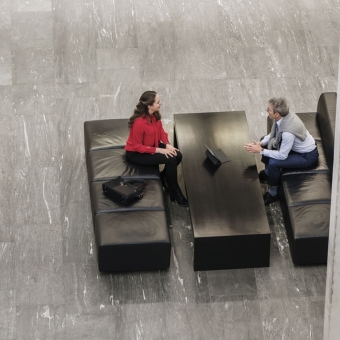 Zwei Personen unterhalten sich in einer Bankfiliale.