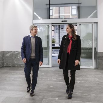 Zwei Personen laufen in einer Bankfiliale hinein.