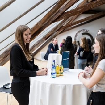 3 Frauen unterhalten sich an einem Stehtisch
